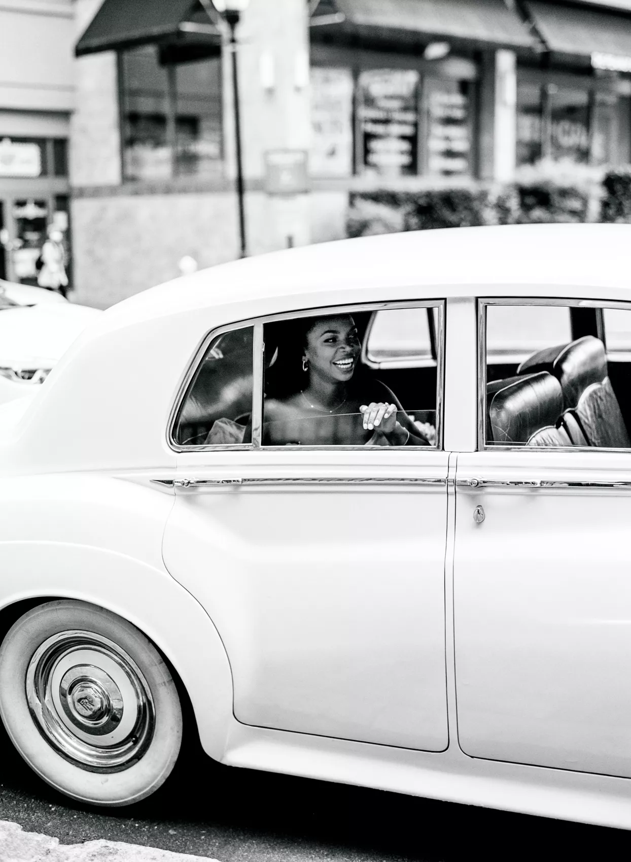 bride in the backseat of vintage wedding car