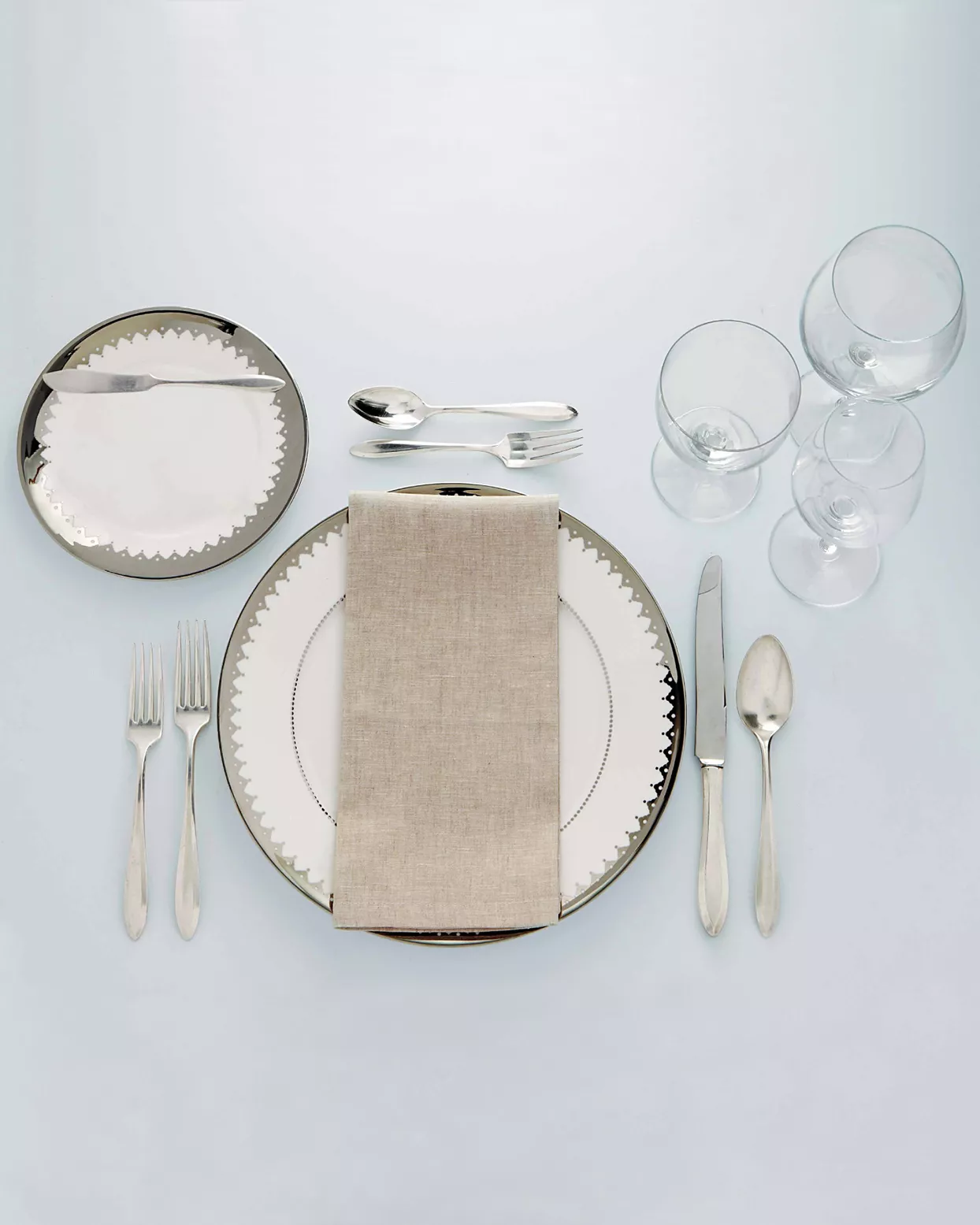 silver and white place setting on blue table