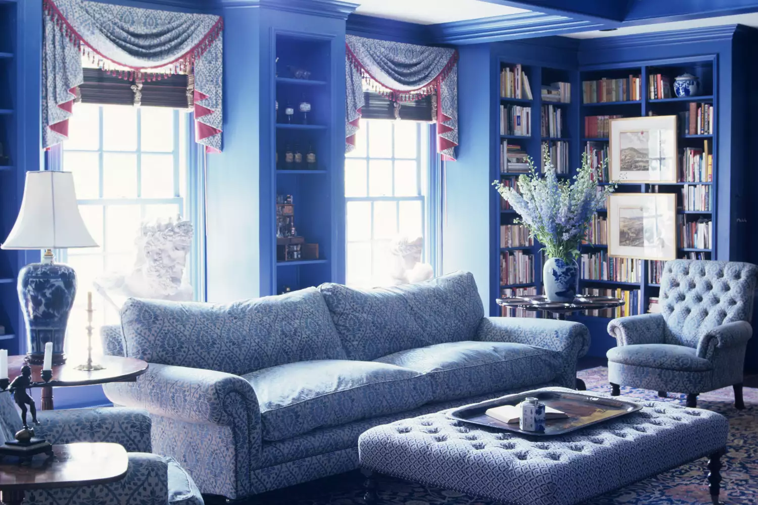 blue living room with complementary patterns on curtains, sofa and rug